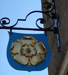 Het wapen van de gemeente Rozendaal (een gouden roos)